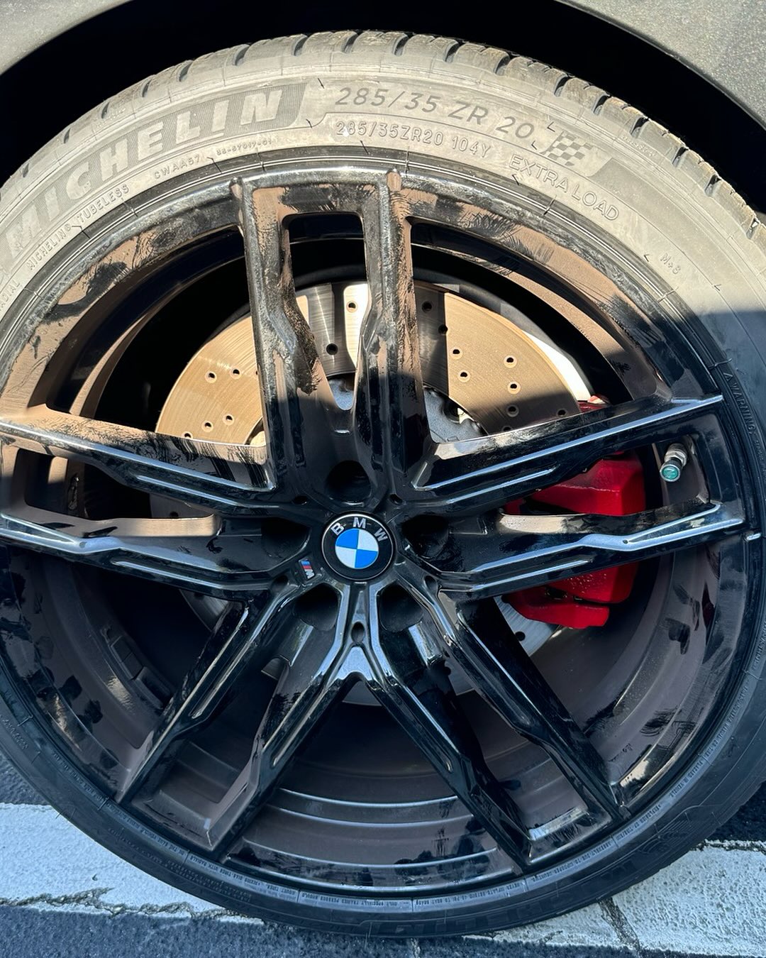 Close-up of a black multi-spoke BMW alloy wheel and tire.
