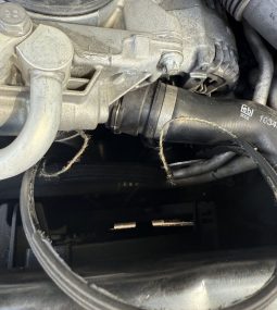 Close-up view underneath a vehicle showing the exhaust pipe and suspension components.